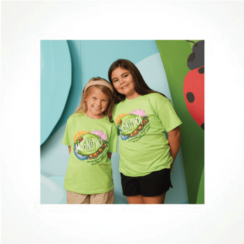 Two children smiling and holding a purple kite