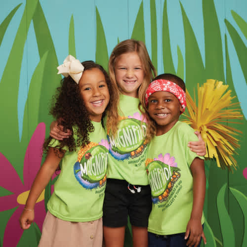 three preschool kids smiling at camera