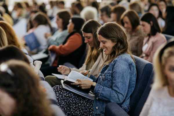 woman reading Bible in audience