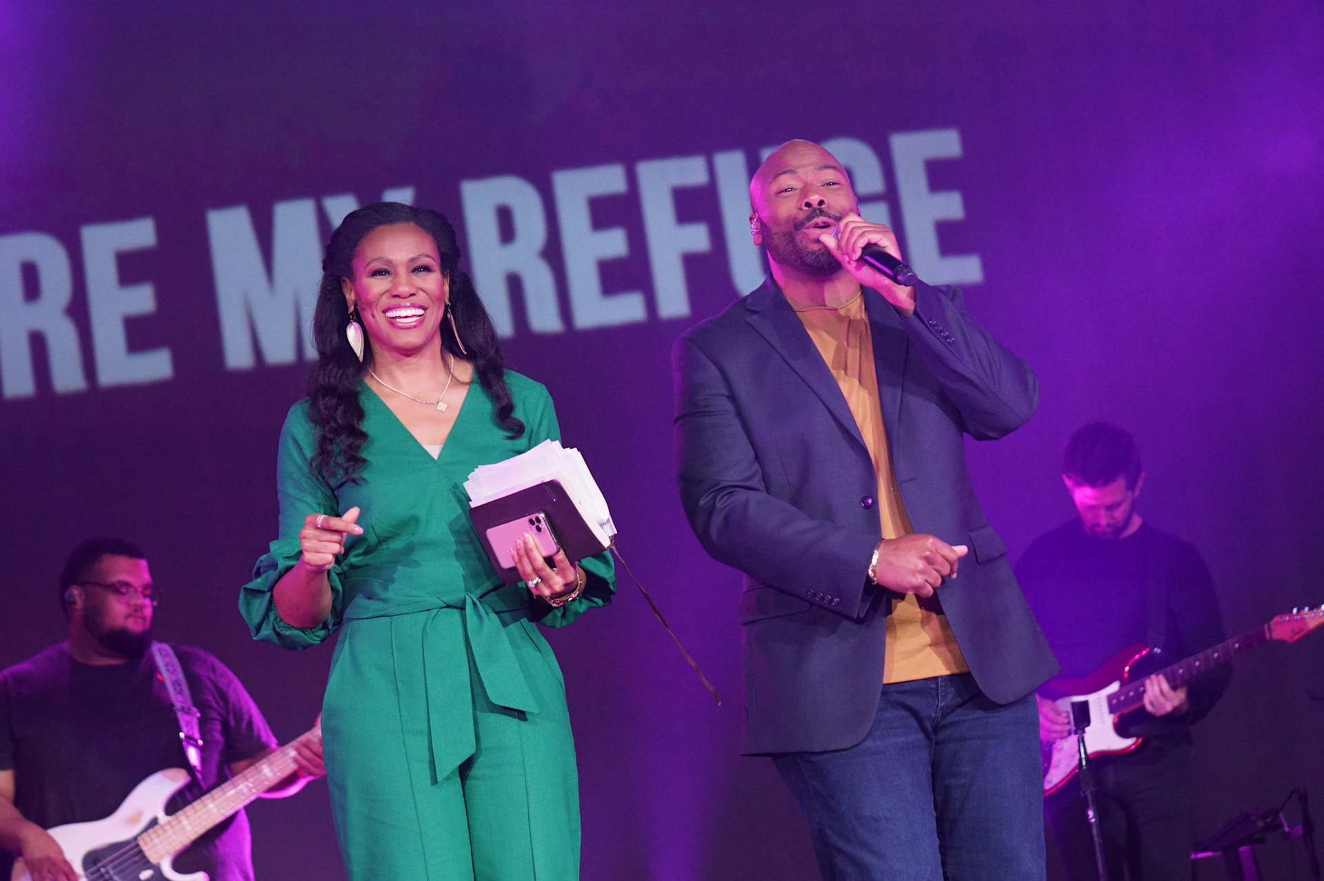 Priscilla Shirer and Anthony Evans on stage together, with Priscilla smiling while holding a book