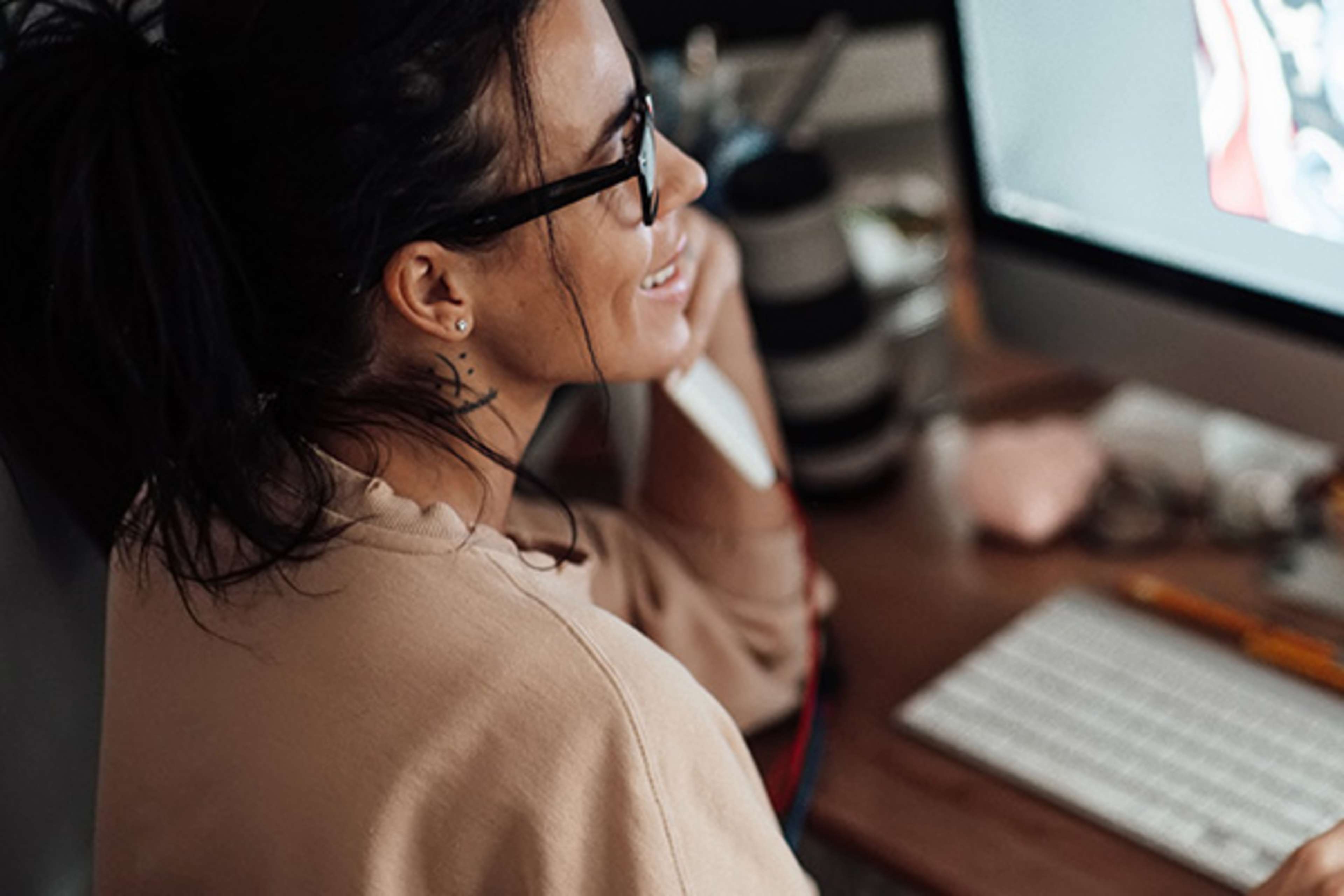 Woman with glasses looking at a computer screen