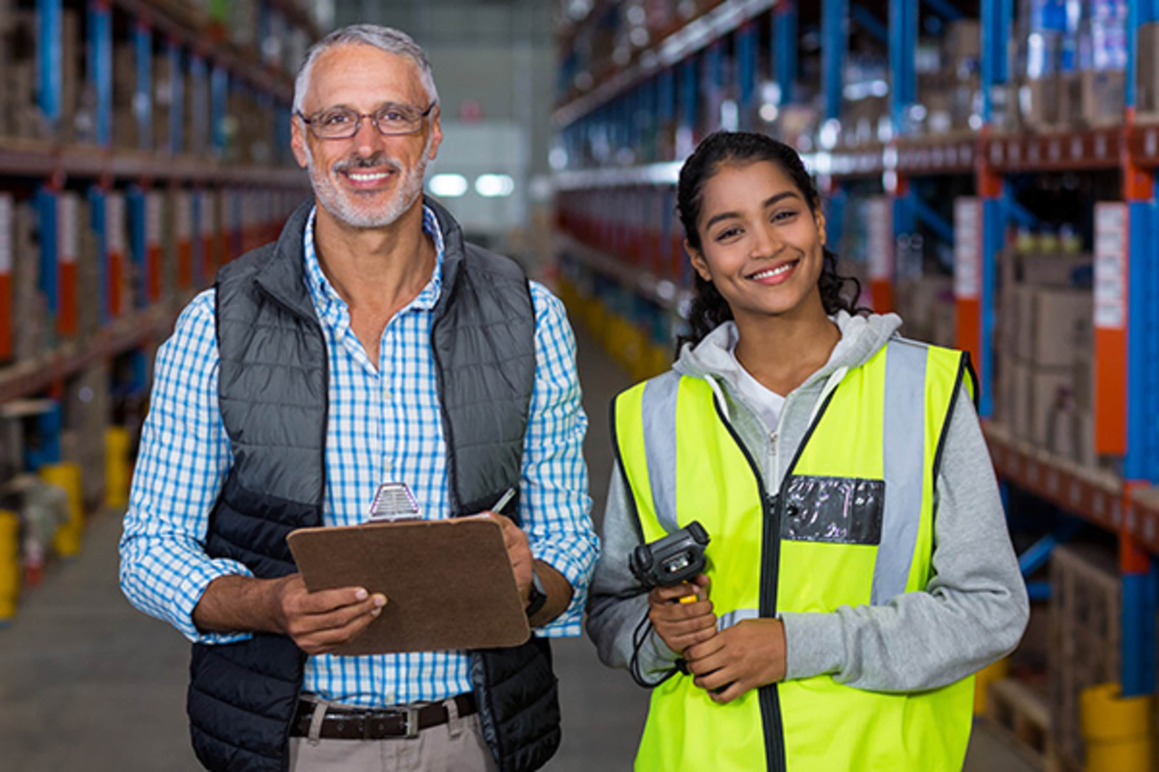 Man holding clipboard and a lady holding a product scanner while smiling