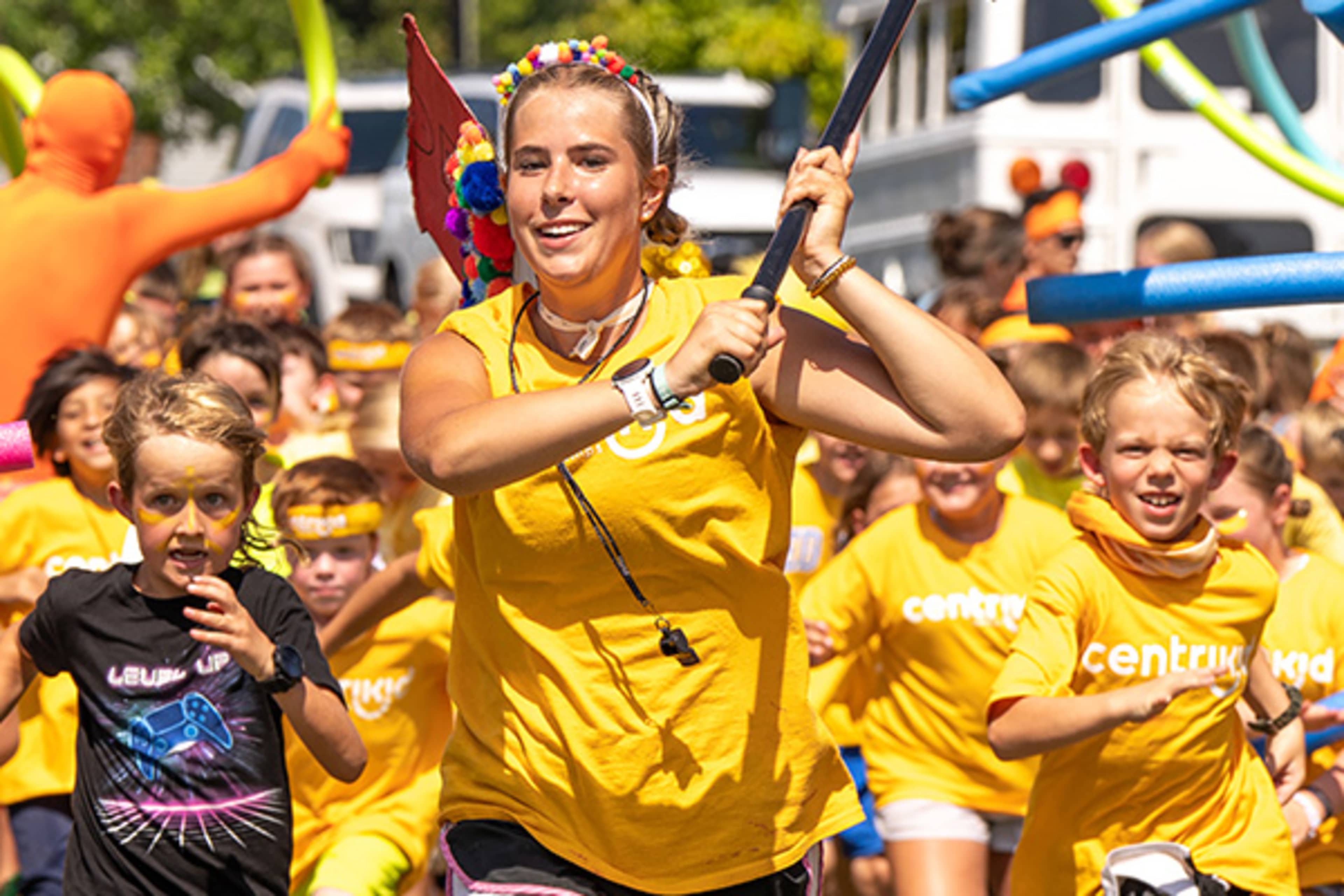 Camp staffer leading group of kids in an outside game