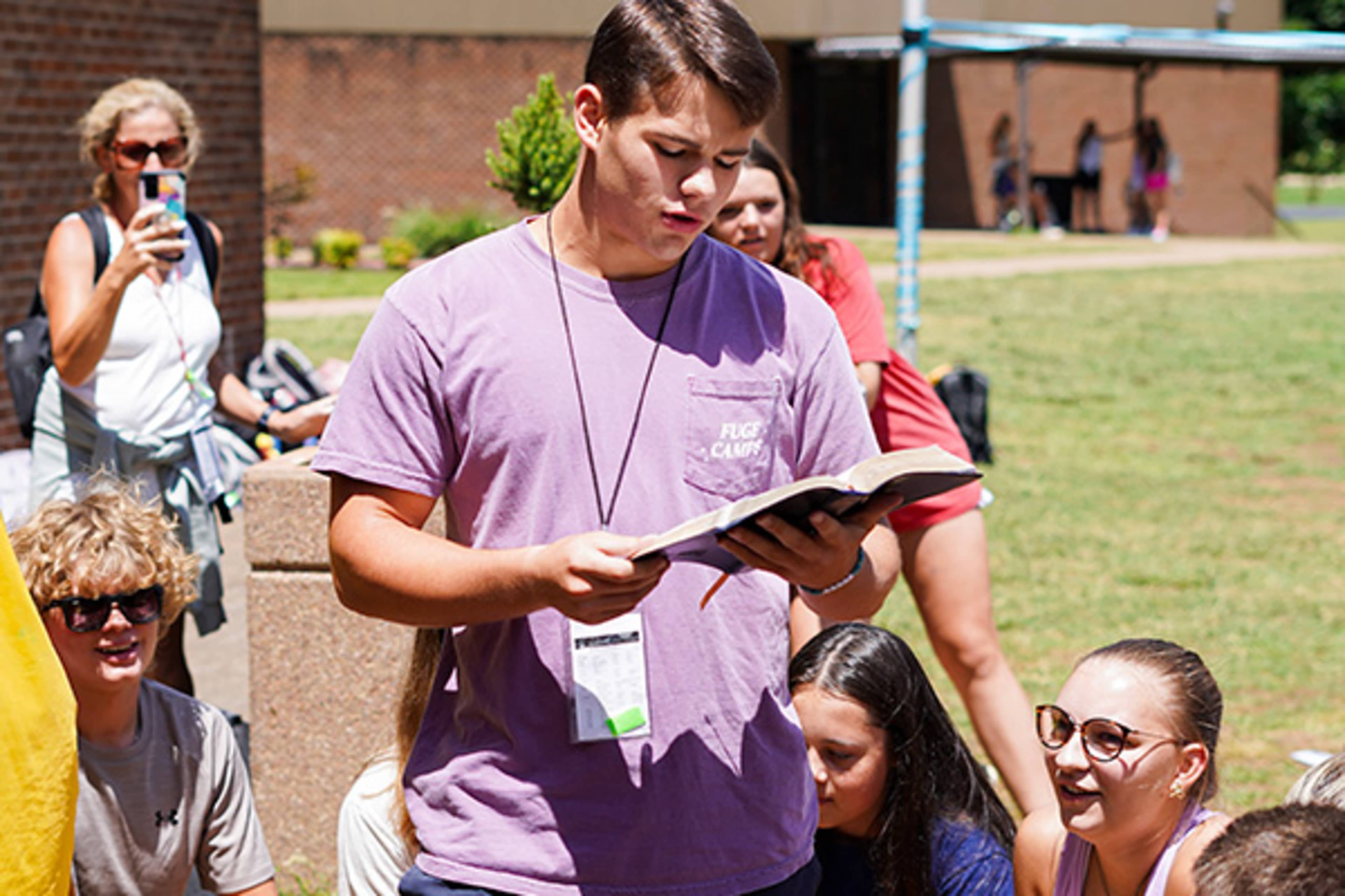 Camp staffer reading the Bible to a group