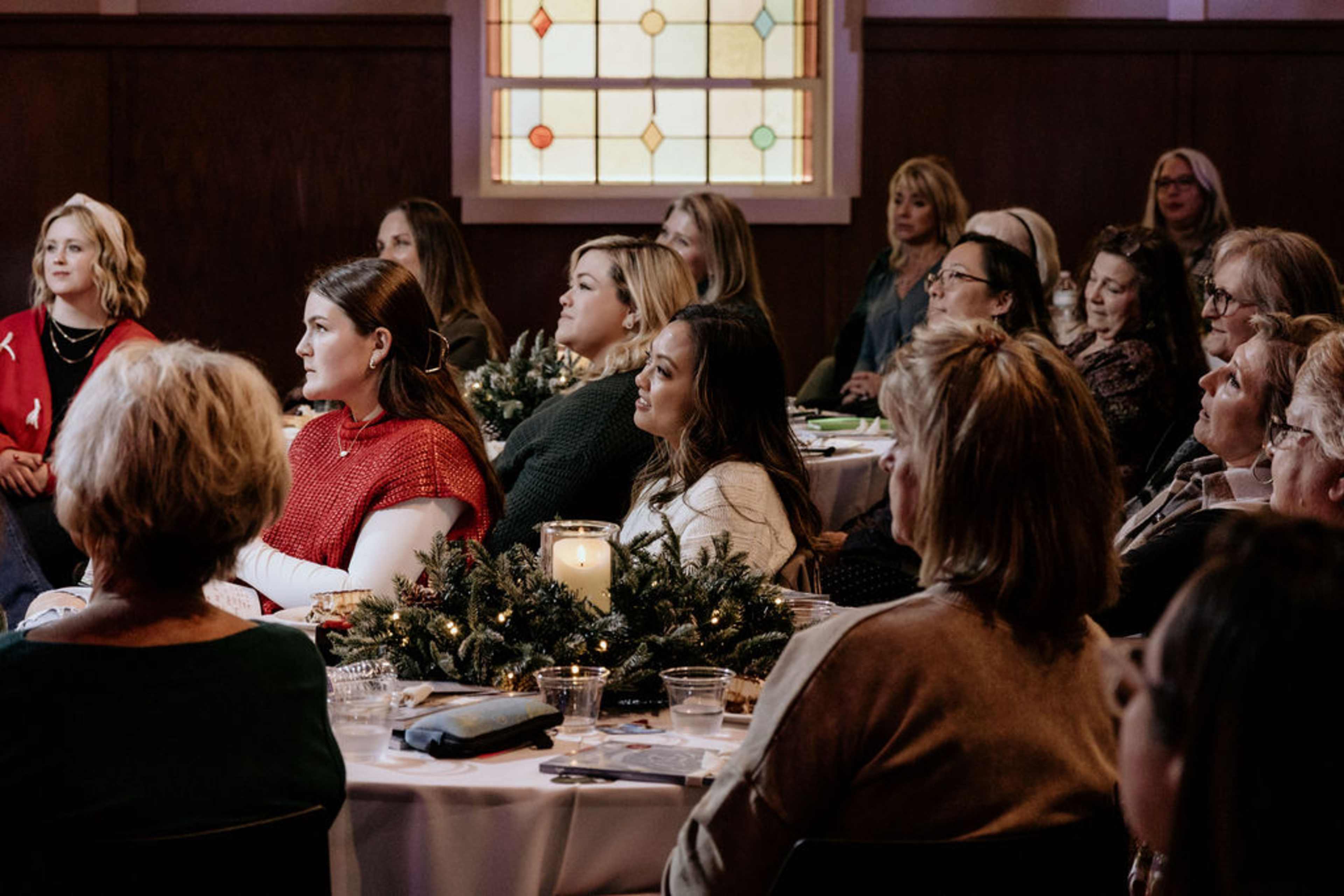 Women sitting at table listening to speaker