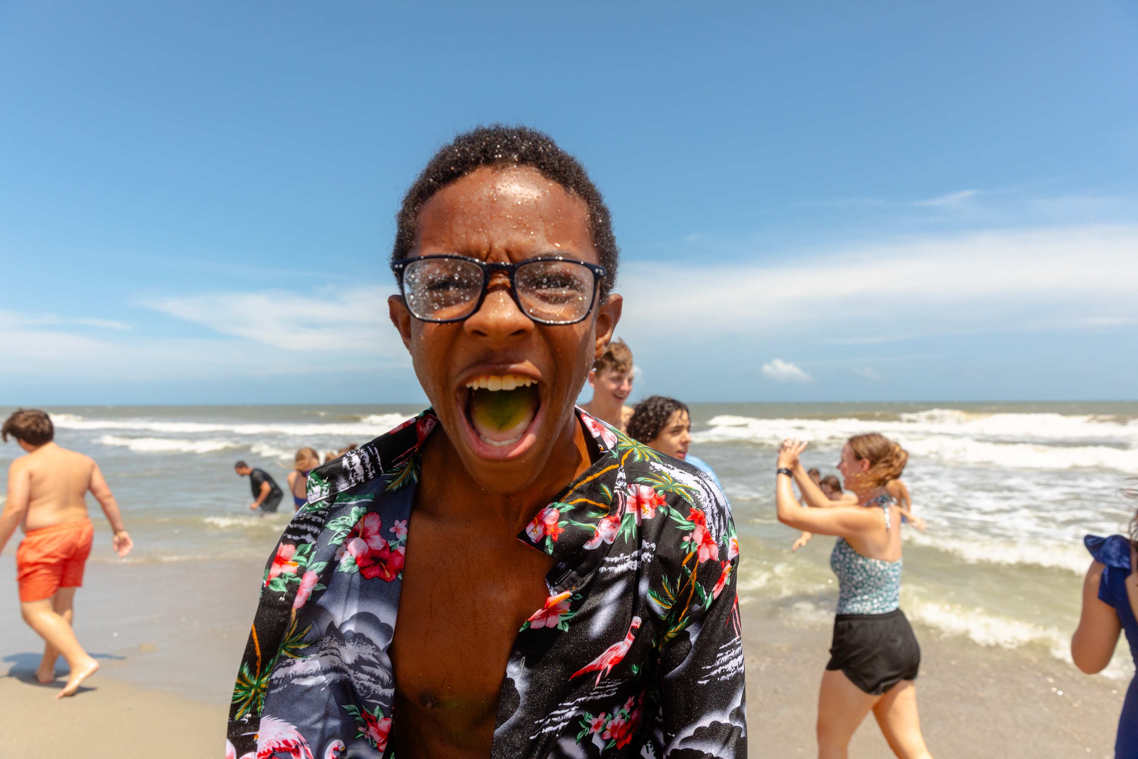 Boy smiling on beach wearing glasses