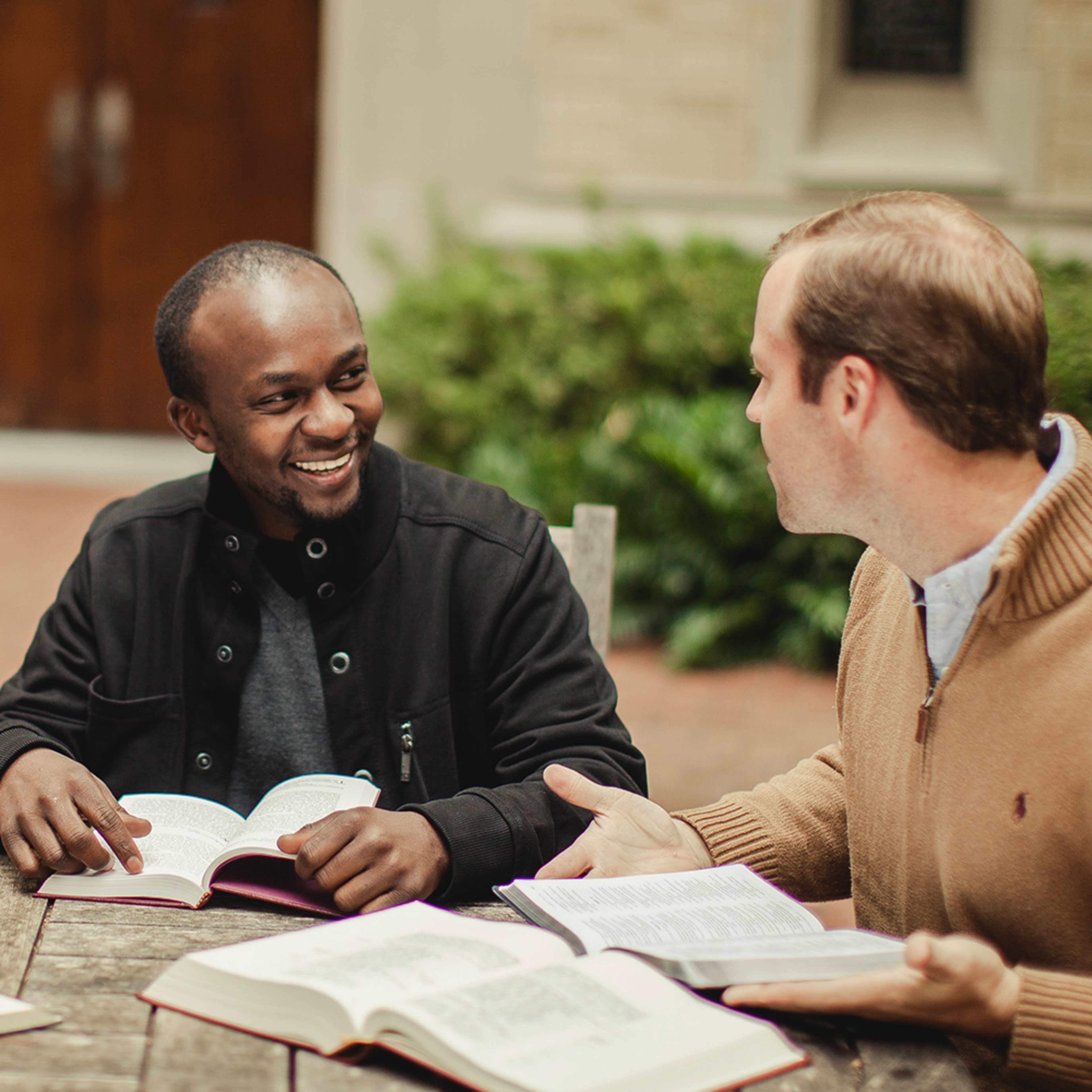 two men talking with bibles