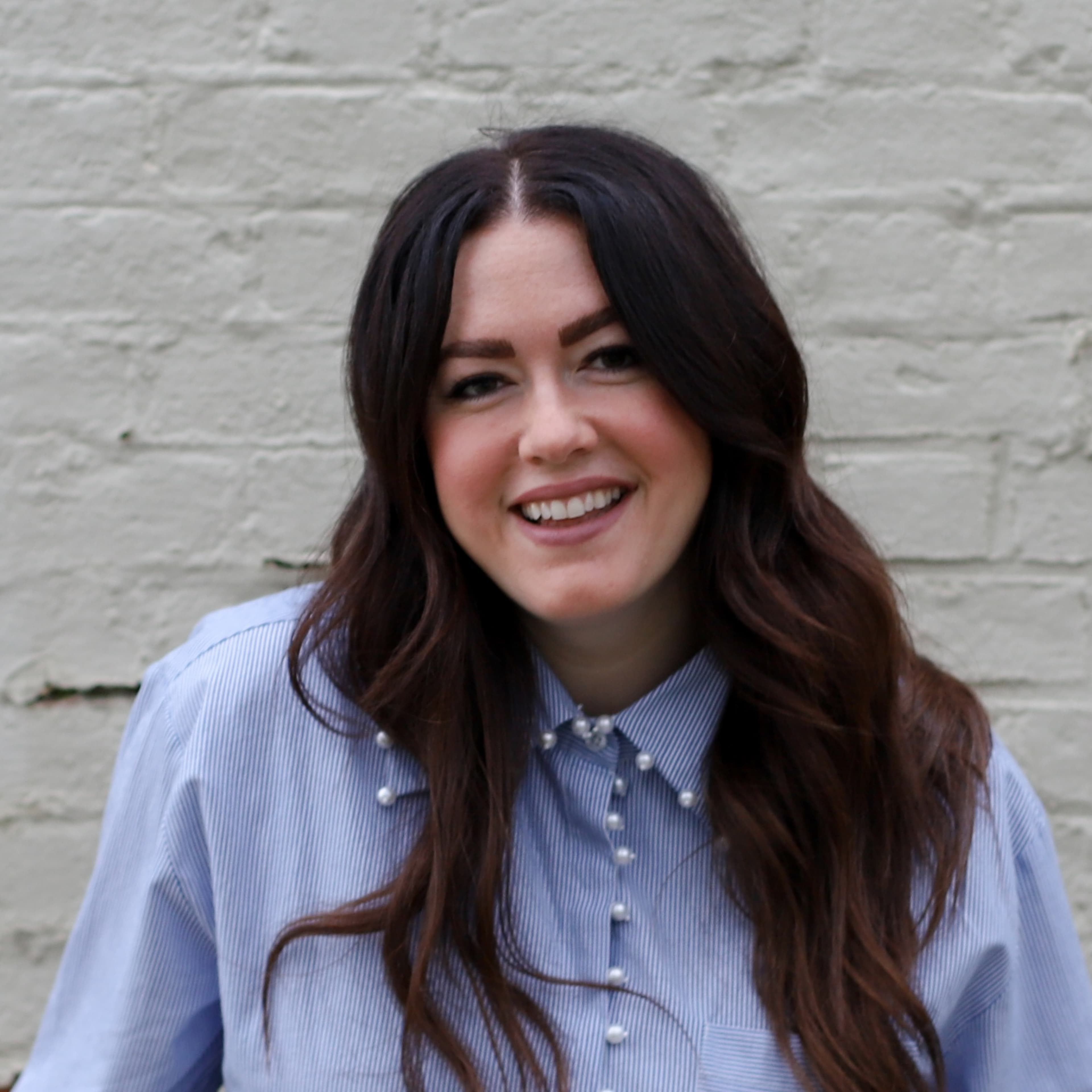 Lindsay McCall in front of white brick wall