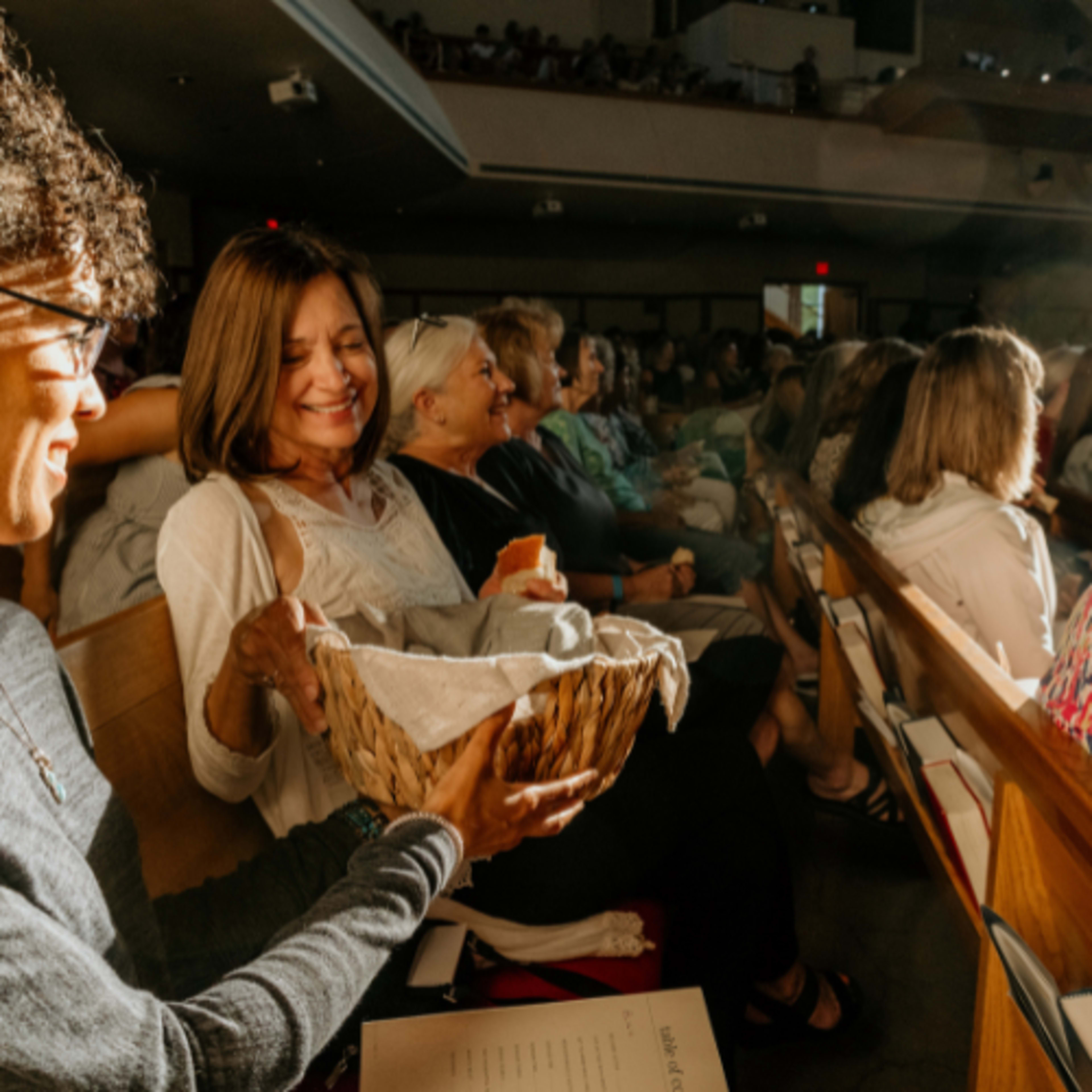 Women passing basket with bread 