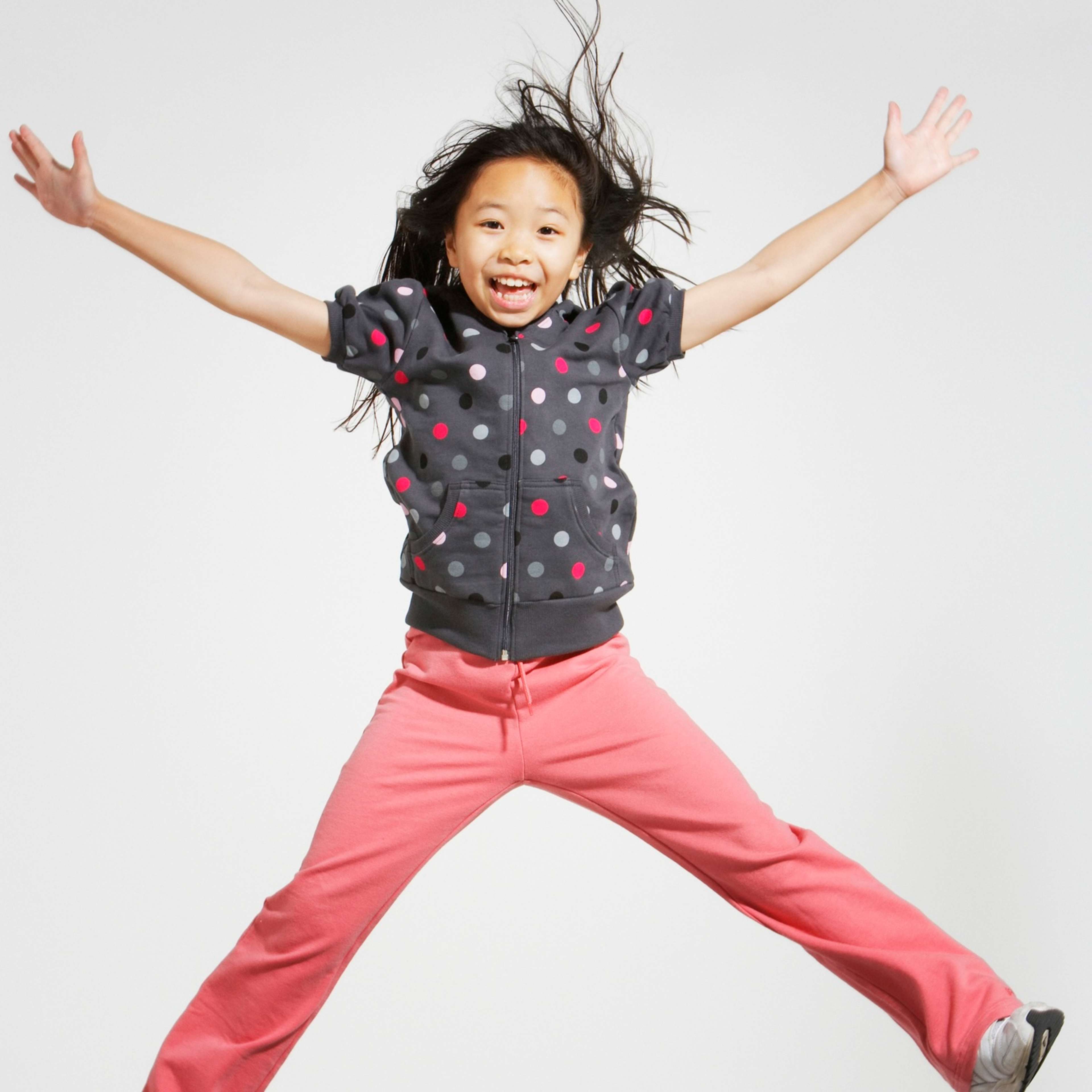 girl jumping black hair and polka dot shirt