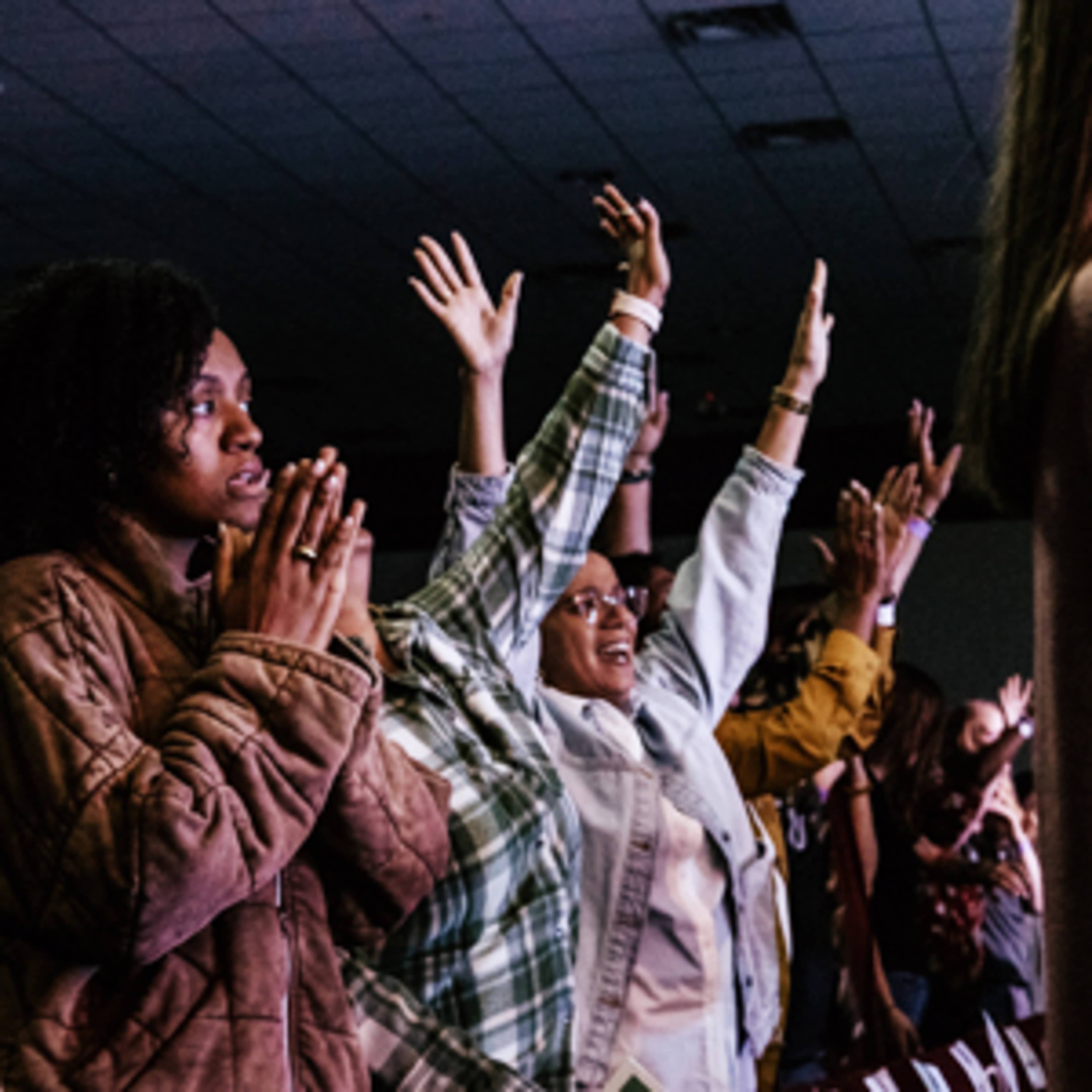Group of women worshipping with raised hands during a church service