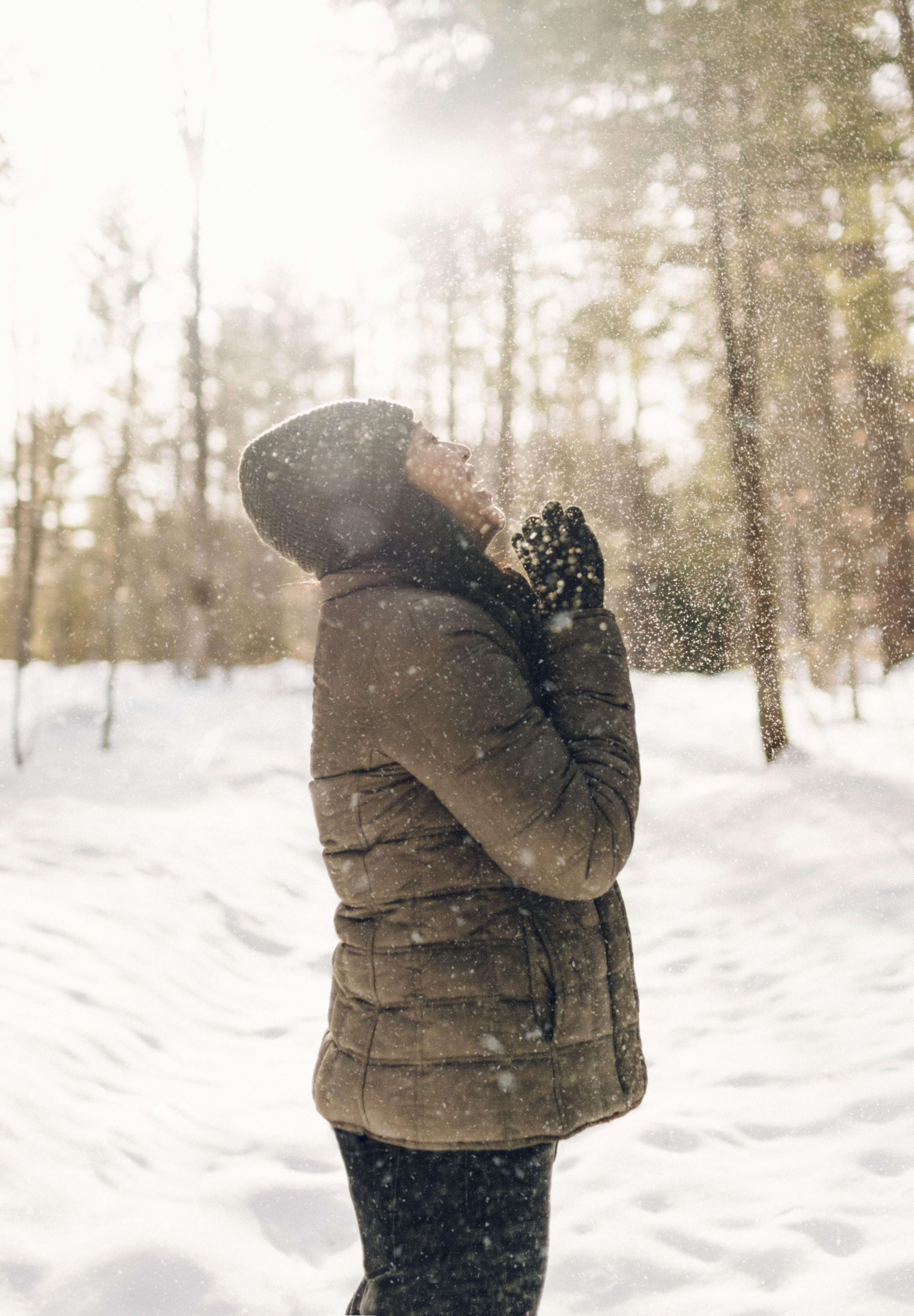Woman in coat playing in snow