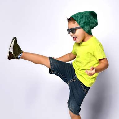 boy with had and sunglasses kicking right foot