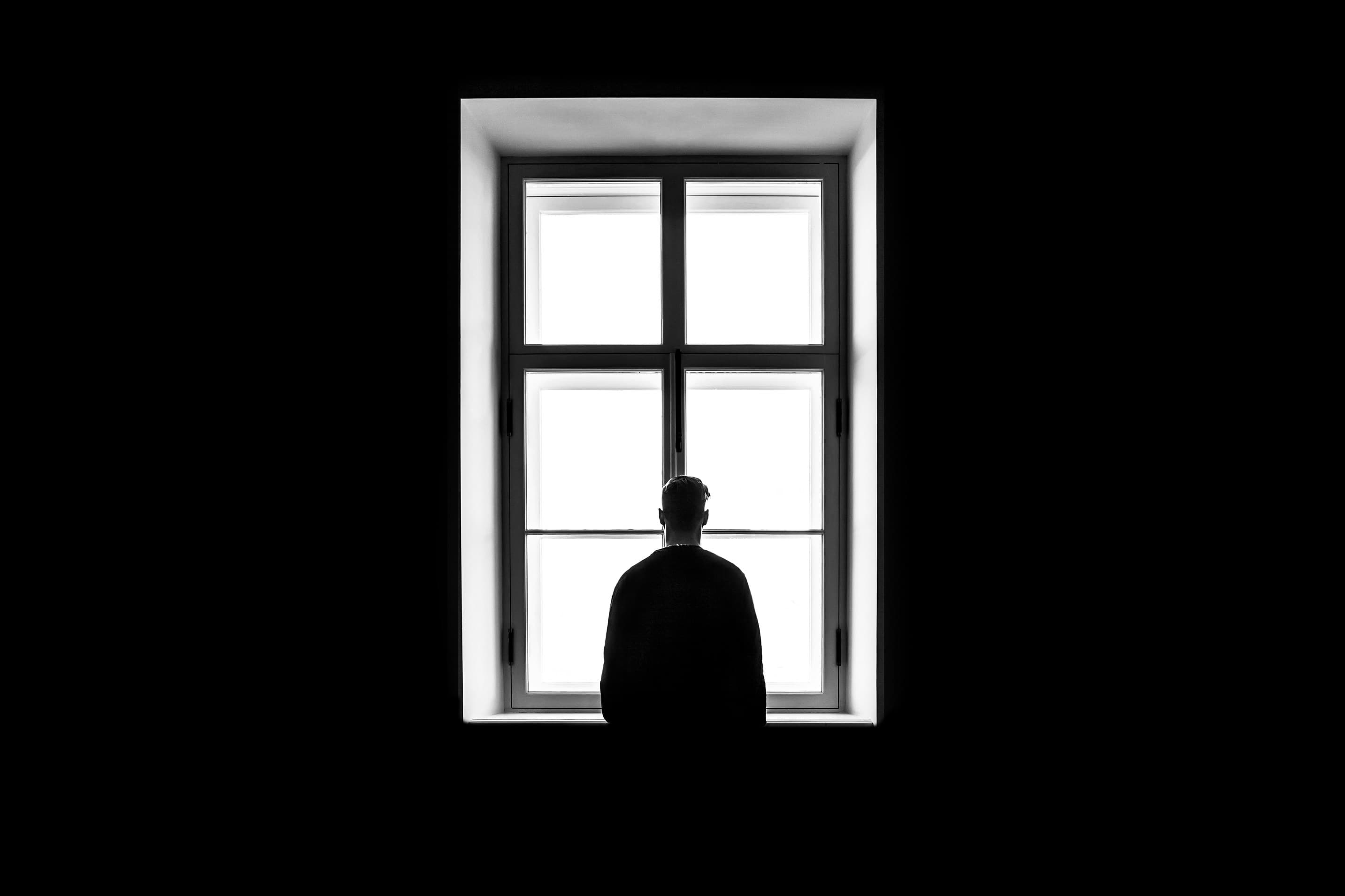 man looking out a window