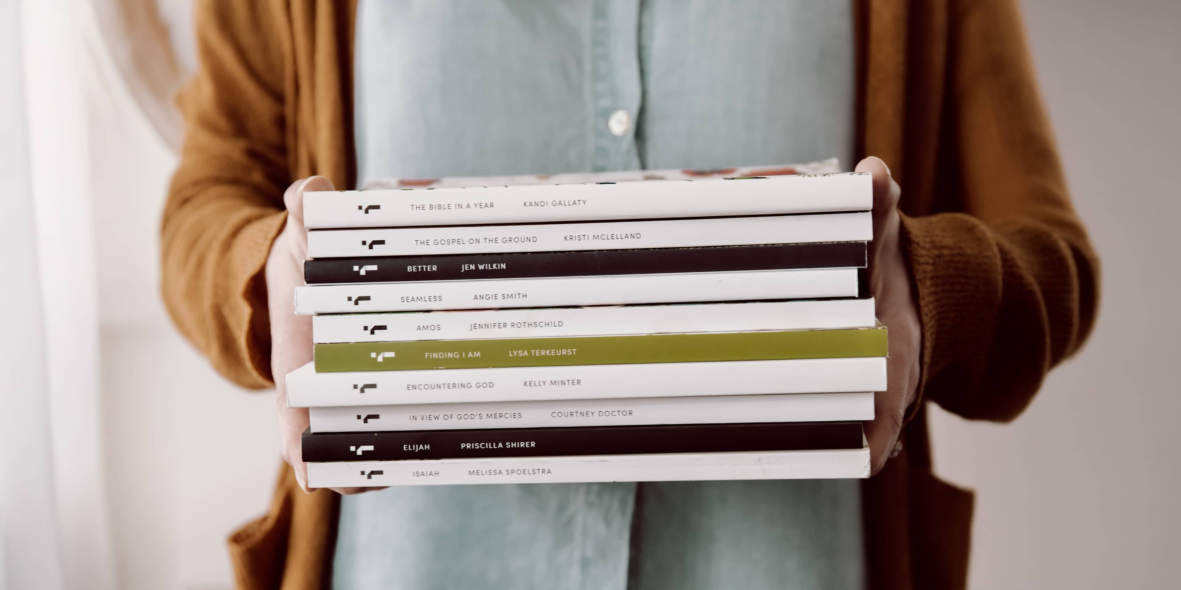 person holding stack of bible studies
