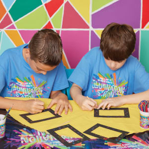 Two boys in blue shirts making a craft picture frame