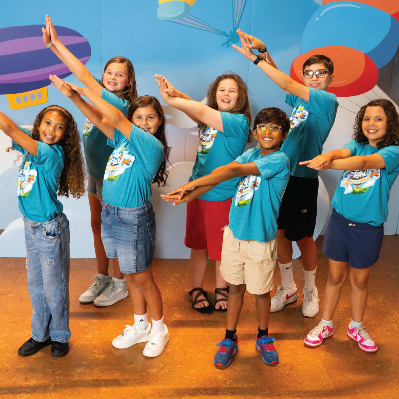 Kids and teens signing and pointing to the right