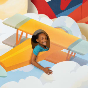 boy holding a cardboard model airplane