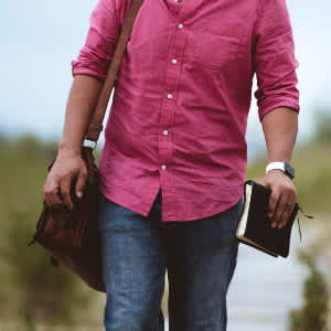 man carrying bag and book