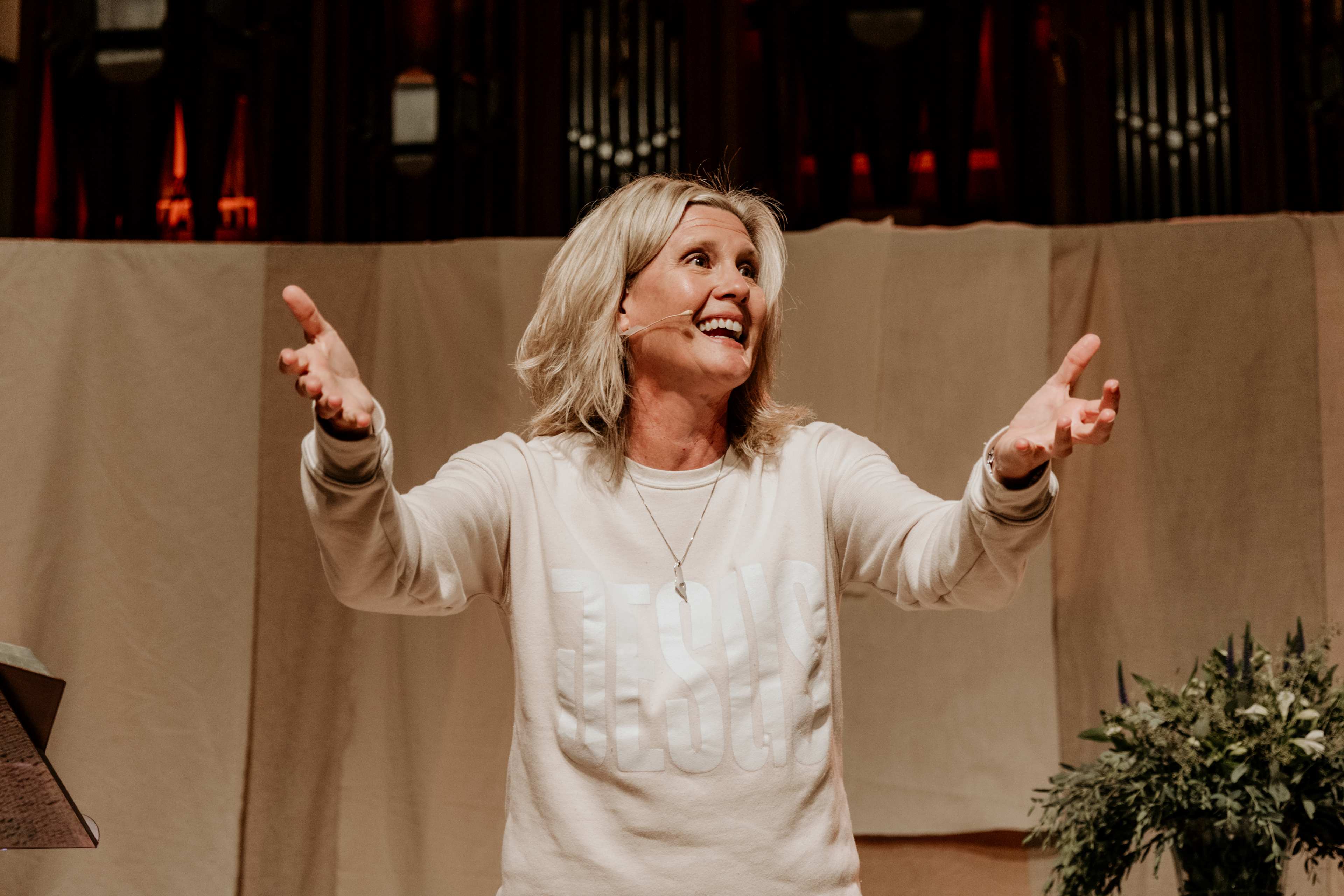 Kristi McLelland speaking with arms raised