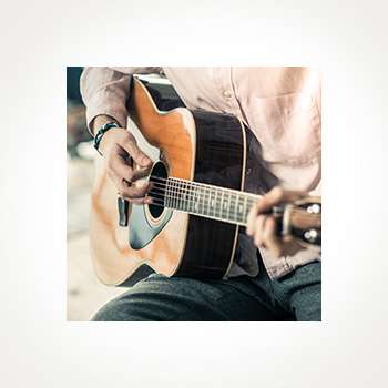 Close-up of a person playing an acoustic guitar