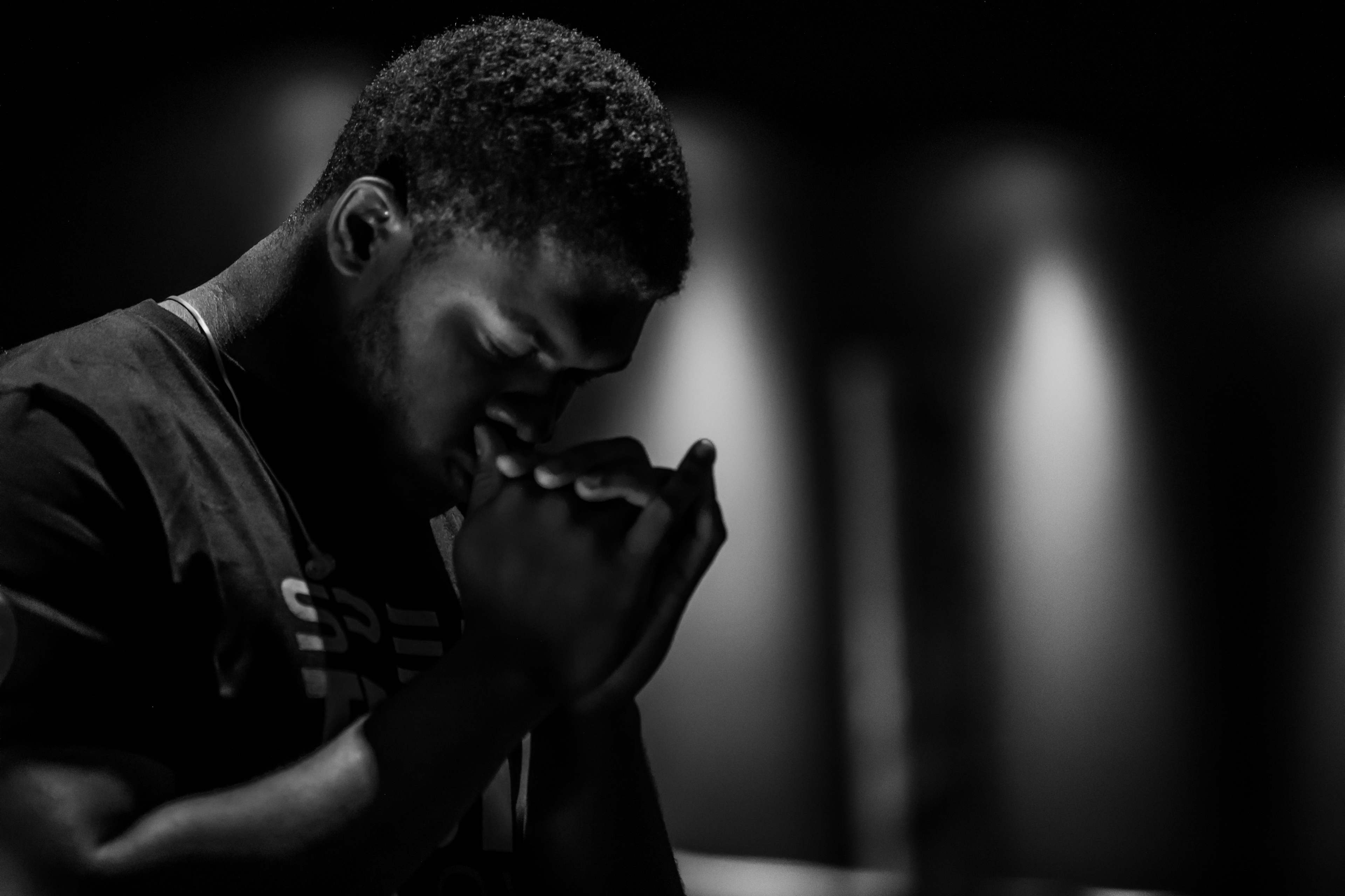 man praying in black and white