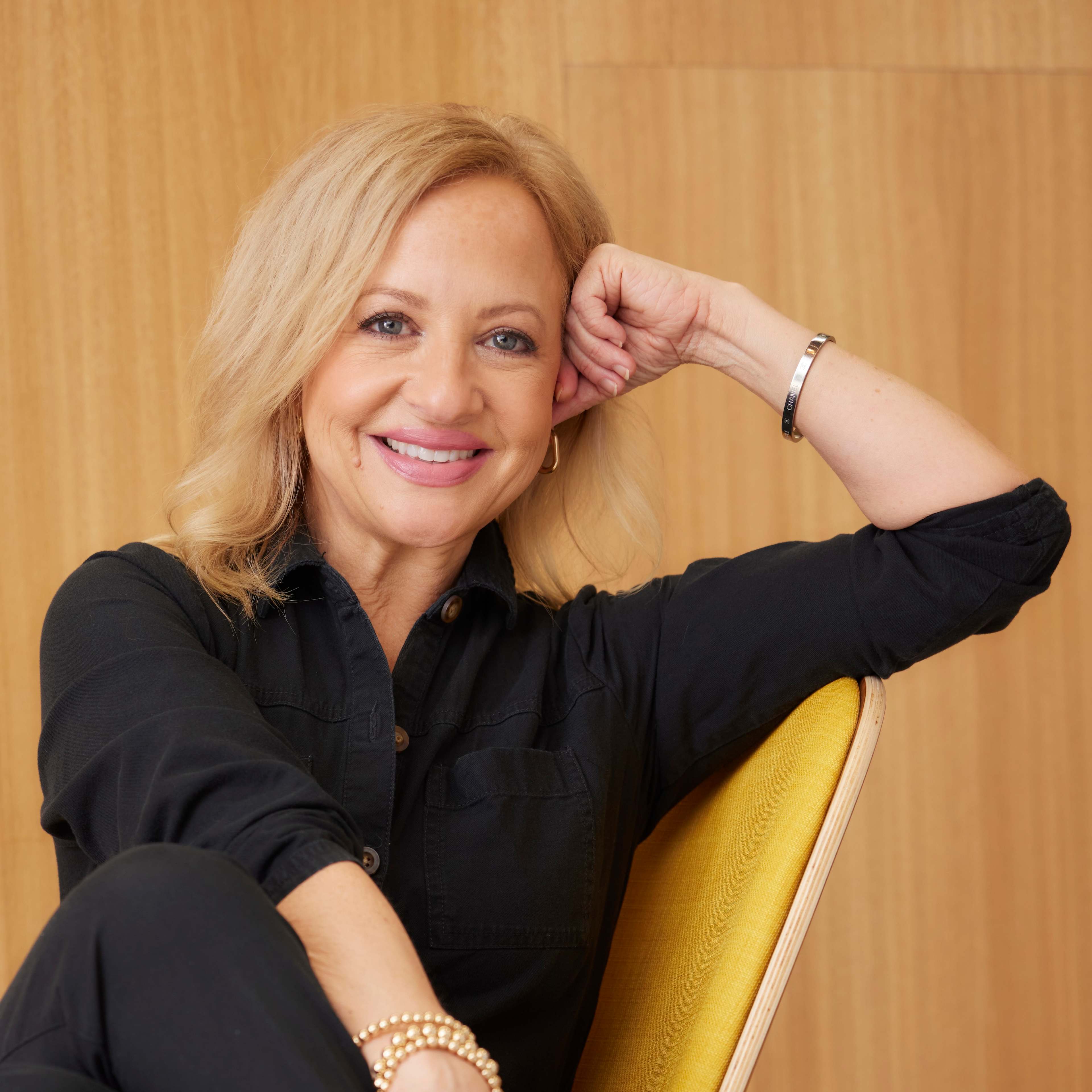 Jana Magruder smiling sitting in chair