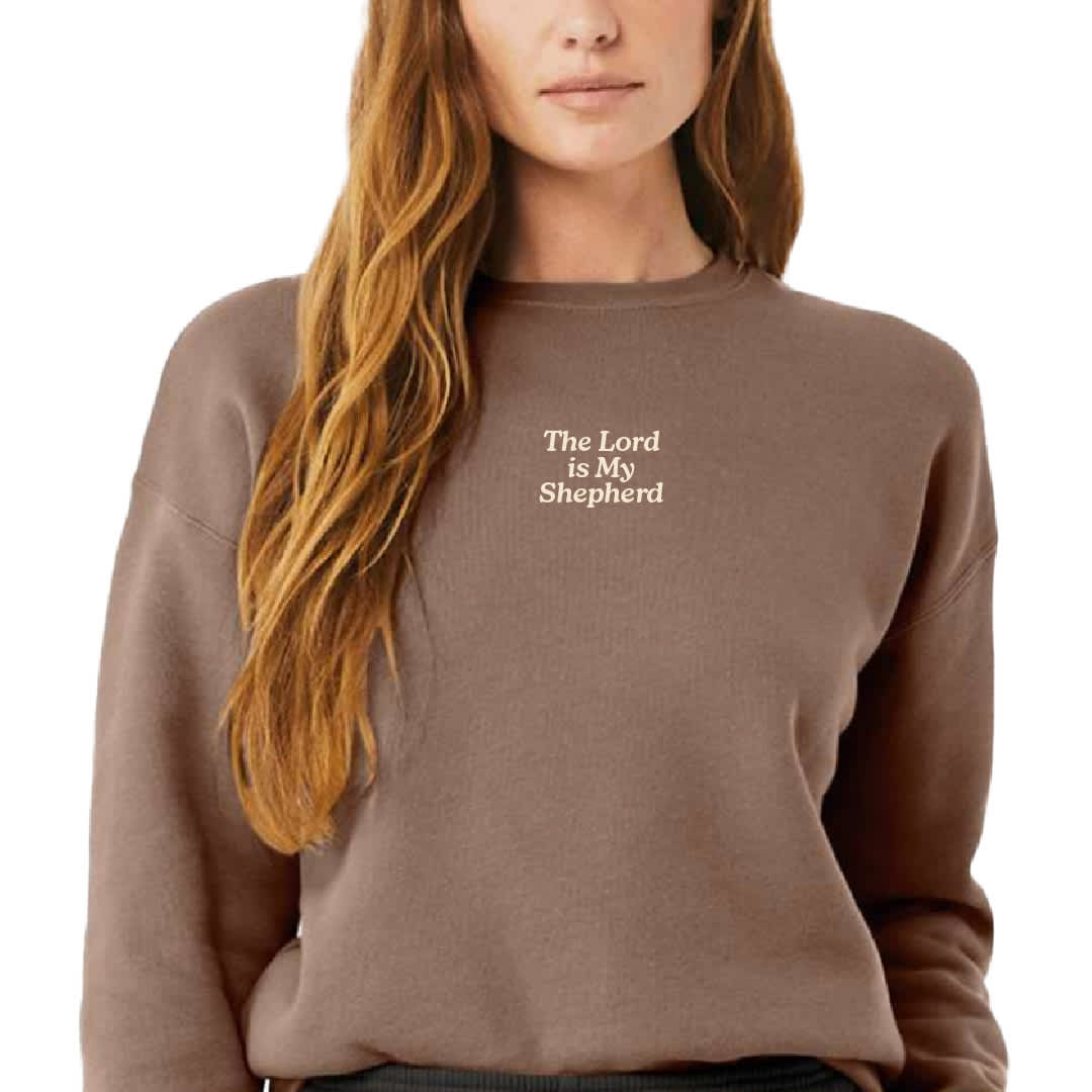 Woman wearing sweatshirt with "the Lord is My Shepherd" on front