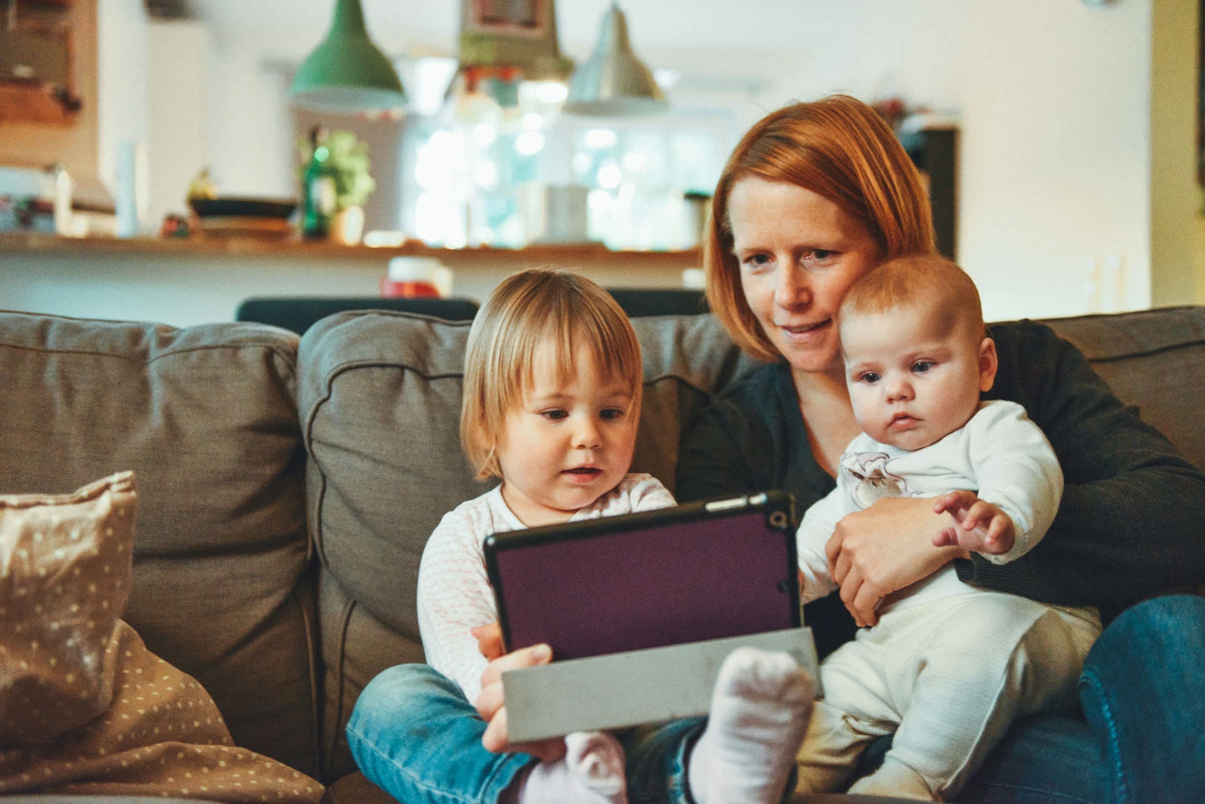 mom watching a tablet with two children