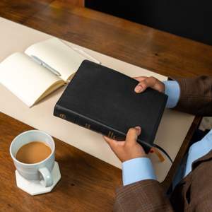 Thinline Bible on a table with a pen and cup of coffee.