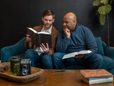 Two men discussing the Bible on a couch